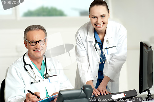 Image of Doctors team. Female assistant typing on keyboard