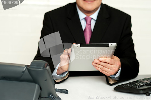 Image of Cropped image of businessman using tablet pc