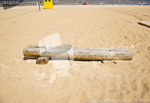 Image of Old broken wooden bench in sea sand. People relax 