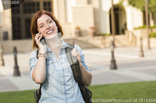 Image of Young Female Student Walking Outside Using Cell Phone