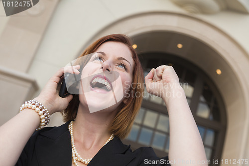 Image of Young Businesswoman with Fist in Air On Cell Phone
