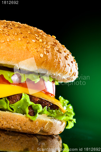 Image of Tasty and appetizing hamburger on a darkly green