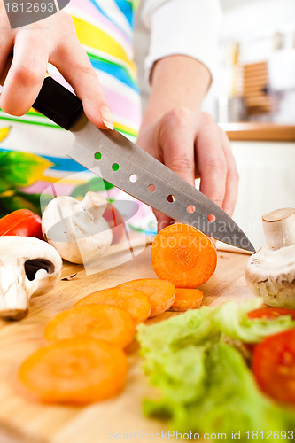 Image of Woman's hands cutting vegetables