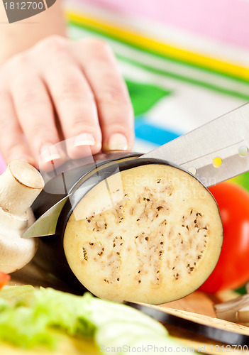 Image of Woman's hands cutting aubergine eggplant