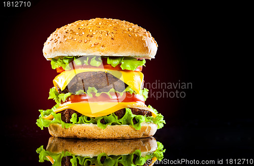 Image of Tasty and appetizing hamburger on a darkly red