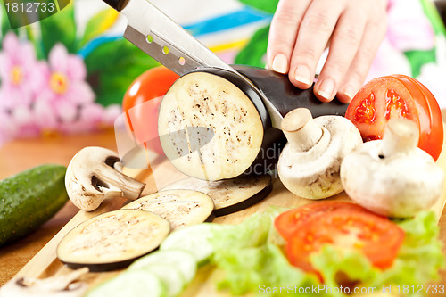 Image of Woman's hands cutting aubergine eggplant