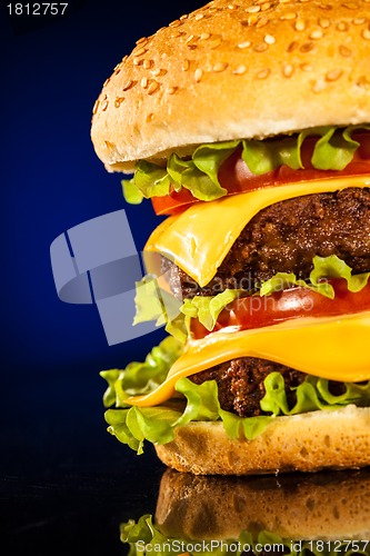 Image of Tasty and appetizing hamburger on a dark blue