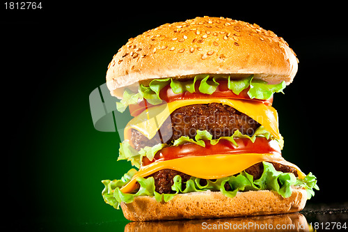 Image of Tasty and appetizing hamburger on a darkly green