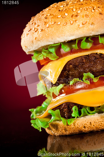 Image of Tasty and appetizing hamburger on a darkly red