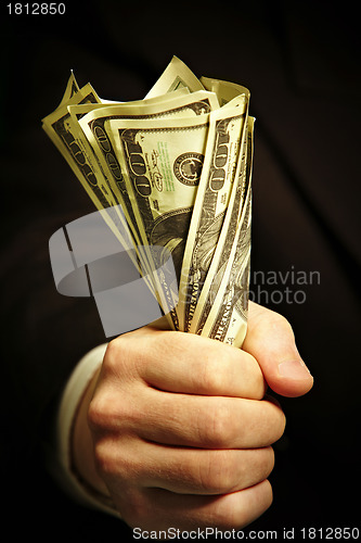 Image of man's hand holds dollars