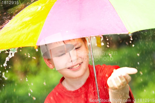 Image of boy under an umbrella during a rain