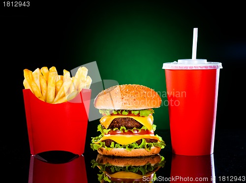 Image of Tasty hamburger and french fries on a dark green