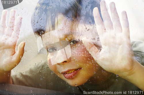 Image of child and window on a wet rainy day