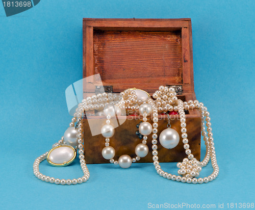 Image of Pearl jewelry in retro wooden box on blue 