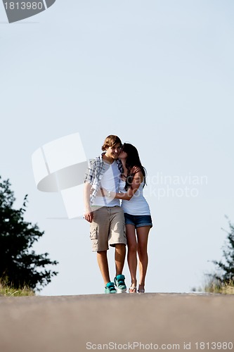 Image of young woman and man is walking on a road in summer outdoor