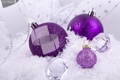 Image of beautiful christmas decoration in purple and silver on white snow