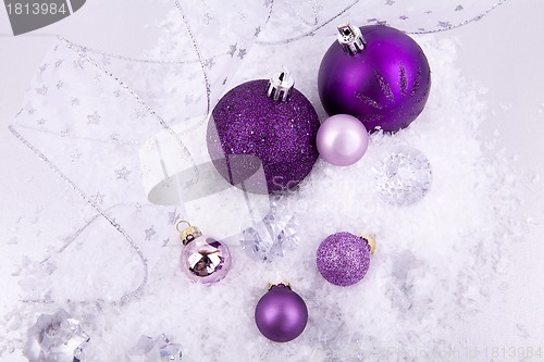 Image of beautiful christmas decoration in purple and silver on white snow