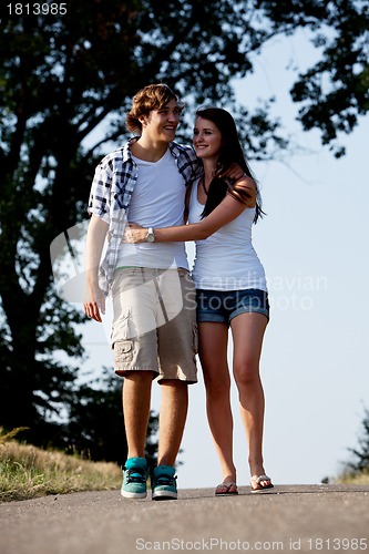 Image of young woman and man is walking on a road in summer outdoor