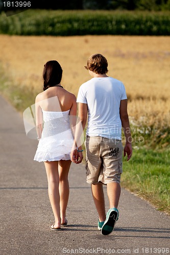 Image of young woman and man is walking on a road in summer outdoor