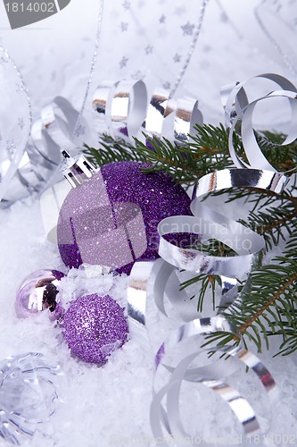 Image of beautiful christmas decoration in purple and silver on white snow