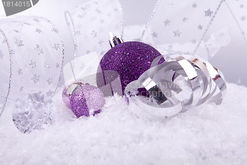 Image of beautiful christmas decoration in purple and silver on white snow