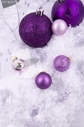 Image of beautiful christmas decoration in purple and silver on white snow