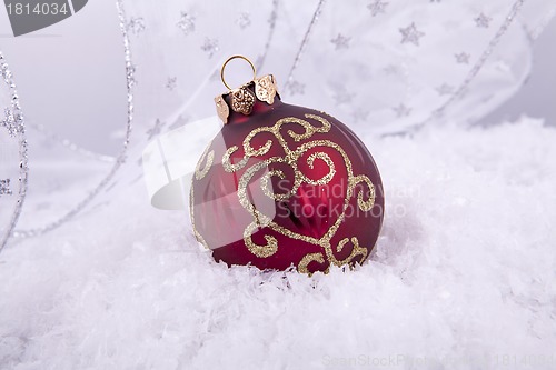 Image of beautiful gold and red christmas decoration on white snow
