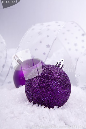 Image of beautiful christmas decoration in purple and silver on white snow