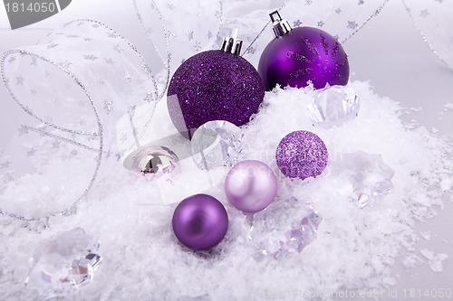 Image of beautiful christmas decoration in purple and silver on white snow