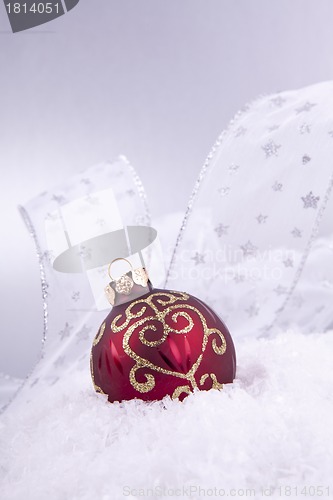 Image of beautiful gold and red christmas decoration on white snow