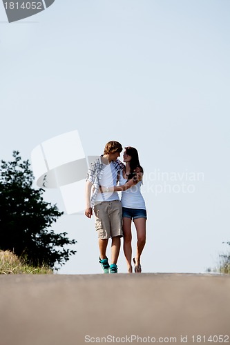 Image of young woman and man is walking on a road in summer outdoor