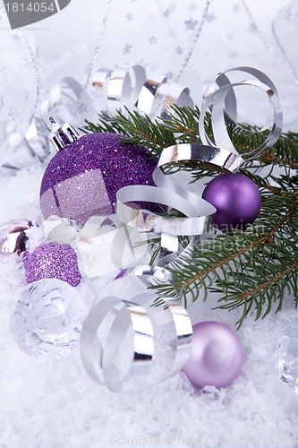 Image of beautiful christmas decoration in purple and silver on white snow