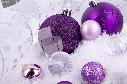 Image of beautiful christmas decoration in purple and silver on white snow