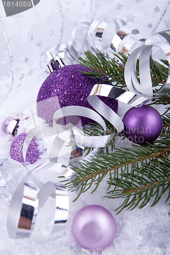 Image of beautiful christmas decoration in purple and silver on white snow