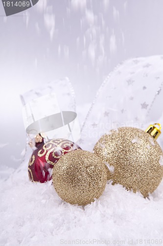 Image of beautiful gold and red christmas decoration on white snow