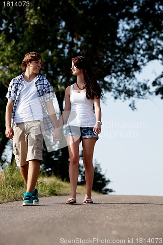 Image of young woman and man is walking on a road in summer outdoor