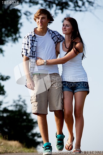 Image of young woman and man is walking on a road in summer outdoor