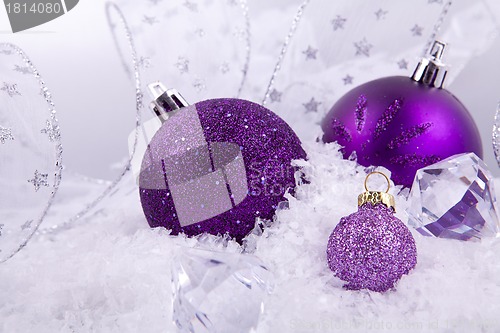 Image of beautiful christmas decoration in purple and silver on white snow