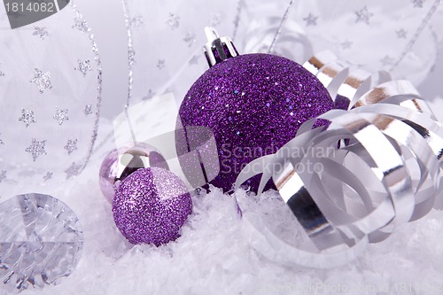 Image of beautiful christmas decoration in purple and silver on white snow