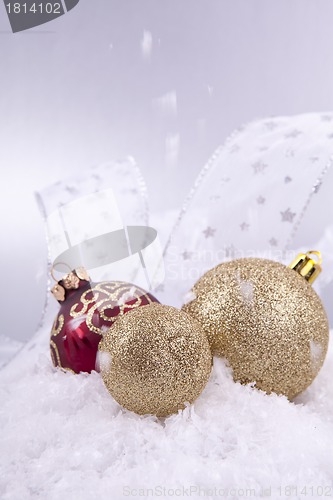 Image of beautiful gold and red christmas decoration on white snow