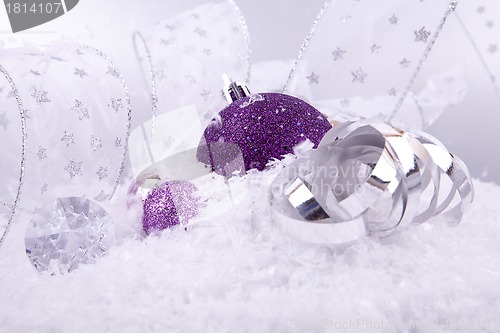 Image of beautiful christmas decoration in purple and silver on white snow