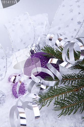 Image of beautiful christmas decoration in purple and silver on white snow