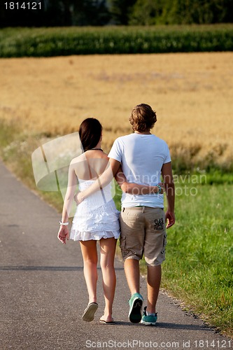 Image of young woman and man is walking on a road in summer outdoor