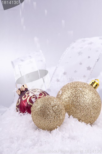 Image of beautiful gold and red christmas decoration on white snow