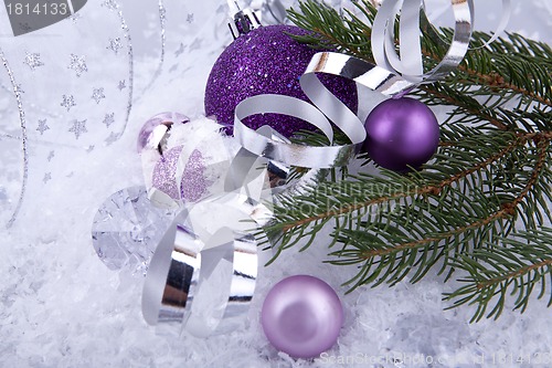 Image of beautiful christmas decoration in purple and silver on white snow