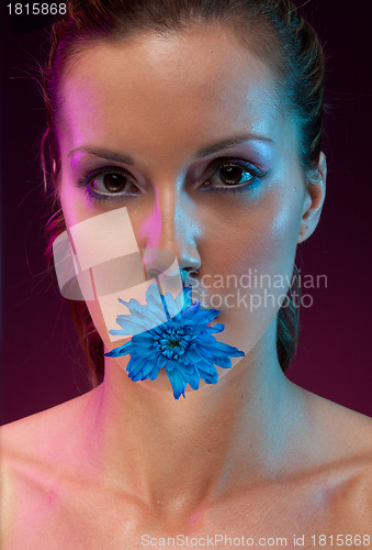 Image of Beautiful woman with flower in mouth