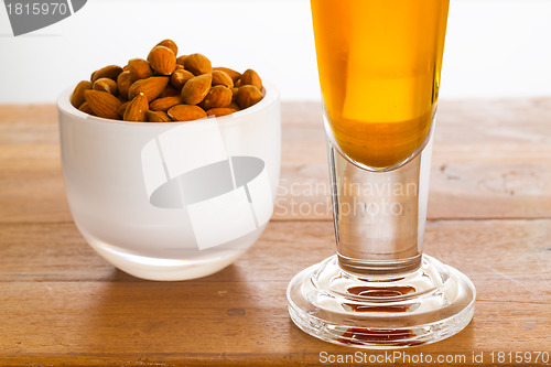Image of Bowl of raw almond nuts on wooden table