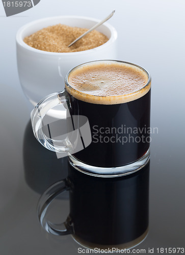 Image of Black coffee and froth in glass mug with sugar