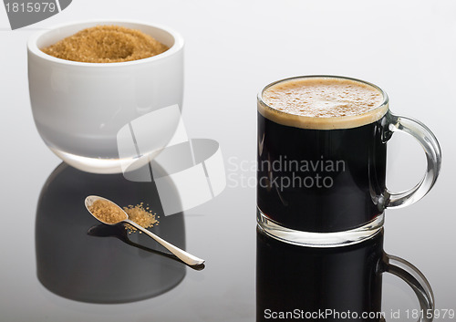 Image of Black coffee and froth in glass mug with sugar