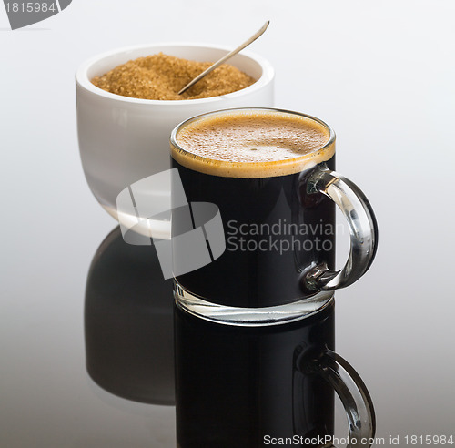 Image of Black coffee and froth in glass mug with sugar